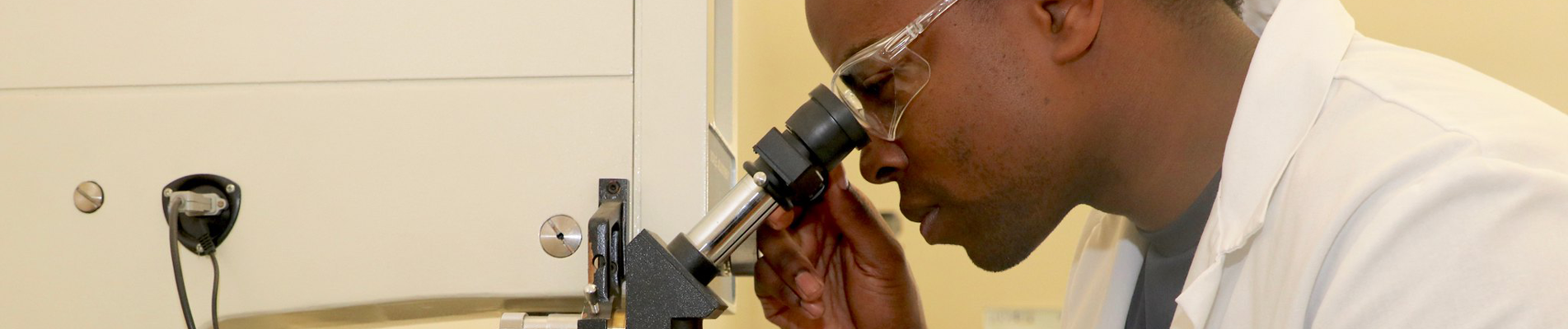 student looking through a microscope