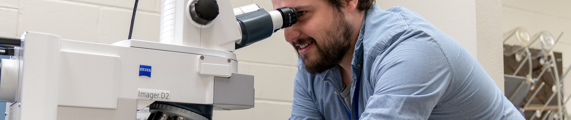 student looking through a microscope