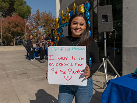 young student standing with a sign